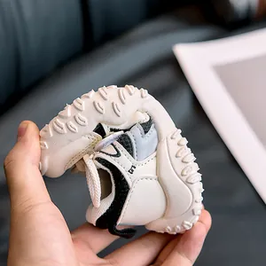 Close-up of flexible soft sole baby sneakers with anti-slip rubber grip dots in black and white