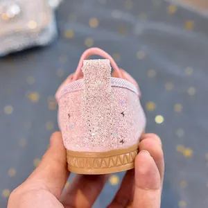 Detailed close-up of pink glitter girls' shoes featuring sequins and butterfly prints
