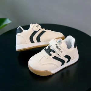 Vue détaillée des chaussures pour bébés crème avec rayures noires et semelle en gomme