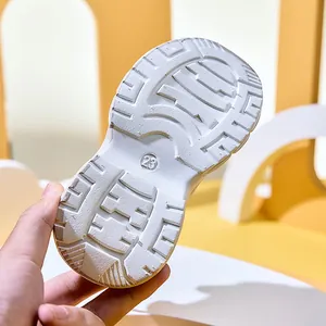 Close-up of durable anti-slip sole on white kids sneakers featuring size 23 mark