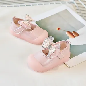 Détail de chaussures roses pour bébé avec nœud en maille perlée et velcro