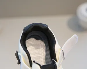 Dettaglio di scarpe per bambini in pelle morbida con chiusura a strappo e fodera nera