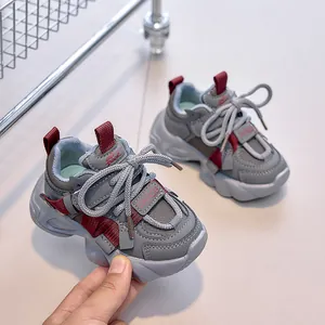 Detail of grey kids chunky sneaker with red trim and non-slip thick rubber sole