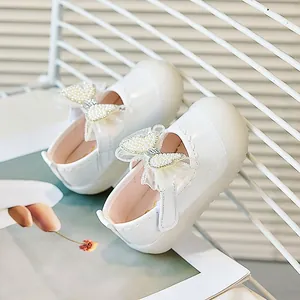 Détail de chaussures Mary Jane blanches pour filles avec nœud en perles et bout en caoutchouc