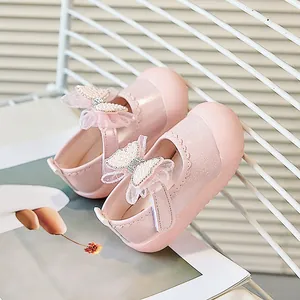 Détail de chaussures de princesse roses pour bébés avec nœud en dentelle et décorations perles