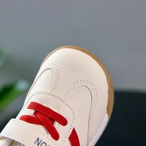 Gros plan de chaussures de sport bébé rétro avec lacets rouges et embout en caoutchouc