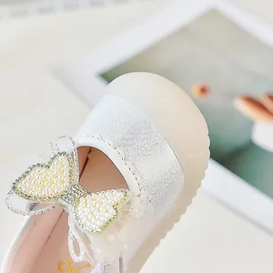 Détail de chaussures princesse bébé avec nœud en perles et texture en maille