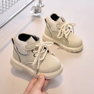 Detailed view of flexible beige suede kids boots with knitted collar and thick rubber sole
