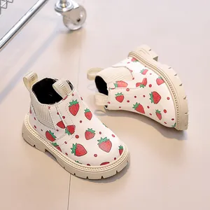 Detail of white kids boots featuring strawberry prints and thick anti-slip rubber soles