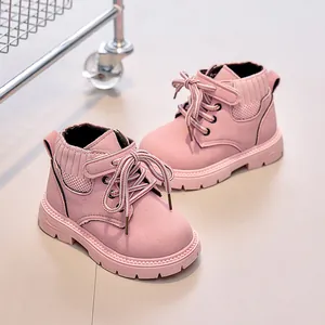 Close-up of pink children boots with lace-up and velcro closure on nubuck leather upper