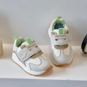 Detail of baby walking sneakers with cartoon dinosaur decor and velcro closure