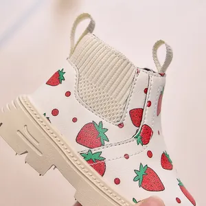 Detail of children's white strawberry print boots with non-slip thick soles and side zippers