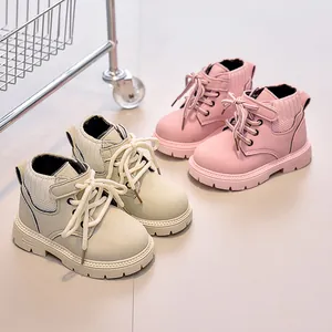 Detail view of pink and beige kids' leather boots with soft knit collars and thick rubber soles
