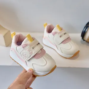 Detailed view of cream baby walker shoe featuring pink accents and cute bunny velcro strap