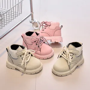 Detail view of durable non-slip rubber soles on pink and beige children's ankle boots