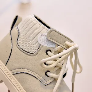 Macro shot of stylish children's cream boots with knitted ankle cuff and velcro strap