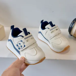 Close-up of white and blue toddler shoes featuring velcro straps and panda detail