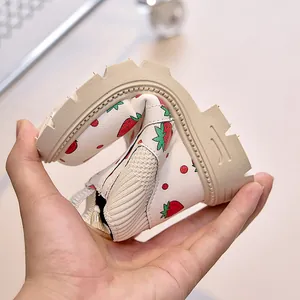 Demonstration of high flexibility with a hand bending the strawberry print baby bootie