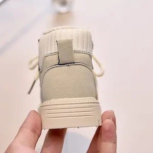 Close-up of beige children's ankle boots with knitted sock collar and non-slip rubber sole