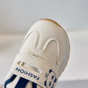 Detail of baby sneakers featuring a cute panda pattern and durable magic tape closure