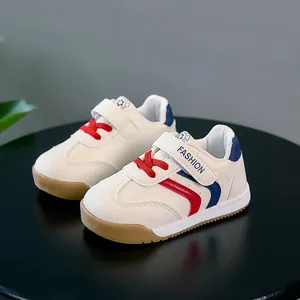Baskets bébé en cuir blanc avec bandes rouges et bleues et fermeture velcro