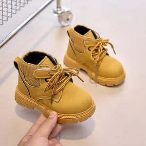 Detail of yellow kids boots featuring suede material and knit collar with velcro strap