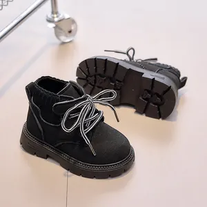 Detail view of children's black leather boots with knitted cuff and anti-slip rubber sole