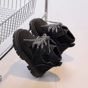 Detail of kids black suede boots featuring knitted collar and striped laces on thick sole