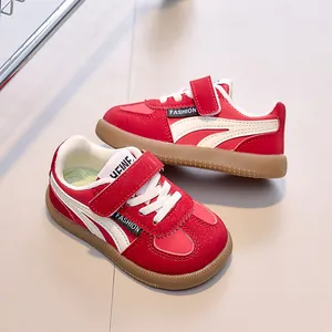 Détail de baskets enfant rouges et blanches avec velcro et semelle en gomme antidérapante