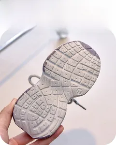 Gros plan sur la semelle violette et grise antidérapante de la basket enfant