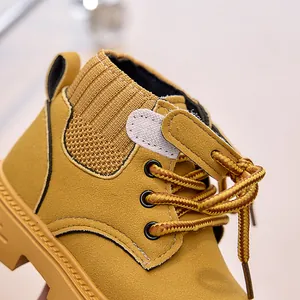 Close-up of mustard yellow kids leather boots with knit collar and stitching detail
