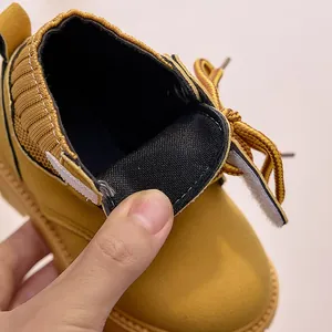 Detail of yellow kids boot with velcro closure and knitted collar for easy wear