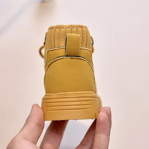 Detailed close-up of children yellow suede ankle boots featuring knitted elastic ankle cuff