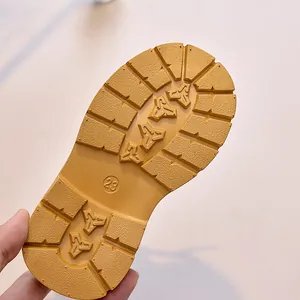 Detailed view of yellow toddler boots showing non-slip rubber sole with size 23 mark
