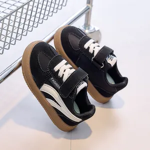 Détail de baskets en daim noir pour enfants avec semelle en gomme et fermeture velcro