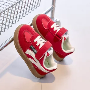 Détail de baskets enfant rouges et blanches avec velcro et semelle en caoutchouc
