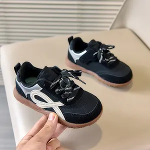 Detail van kindersneaker met retro zijstrepen en duurzame bruine rubberen zool