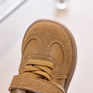 Close-up of children winter sneakers showing brown suede texture and stitching details