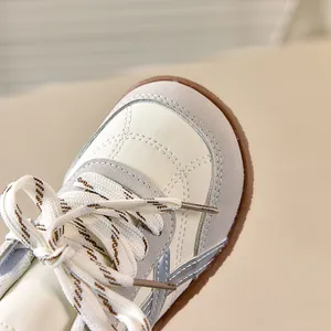 Detailopname van kindersneakers met ruitvormig stiksel en suède patchwork-afwerking