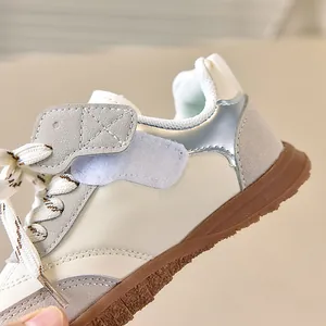 Detail achteraanzicht van vintage kindersneakers met zilveren hiel en rubberen zool
