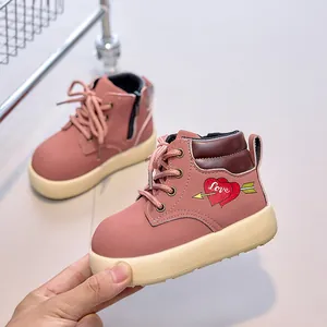 Macro detail of pink leather kids boot showing heart embroidery and side zipper closure