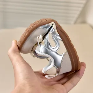 Detailopname van de flexibele rubberen zool van deze zilveren metallic peutersneakers