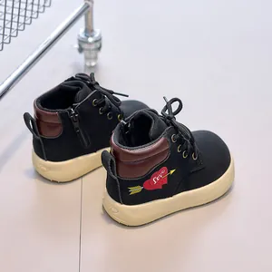 Detailed macro view of black leather kids Martin boots with red heart Love embroidery