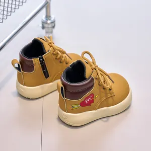 Detail showing kids mustard yellow boots with side zipper, thick sole and heart logo