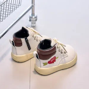 Detail of kids' cream leather boots with side zipper and heart love pattern engraving