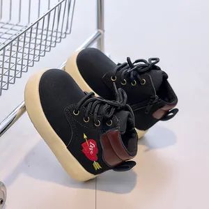 Detail of children's black boots with cream platform sole and heart love embroidery