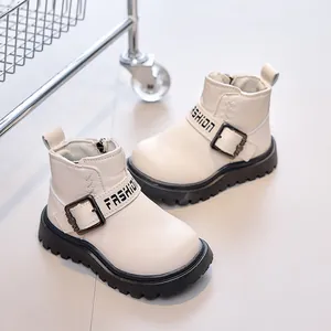 Detailed view of white leather kids boots featuring fashion strap and non-slip rubber sole