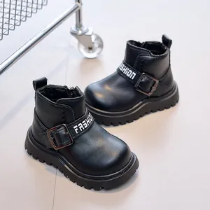 Detail of children's black leather boots with fashion strap and non-slip thick sole