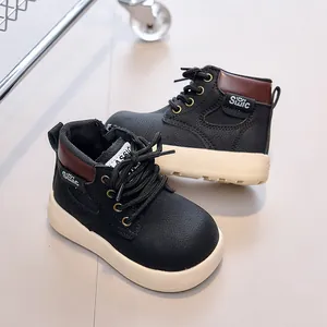 Close-up of black leather kids' boots with anti-slip thick soles and classic laces
