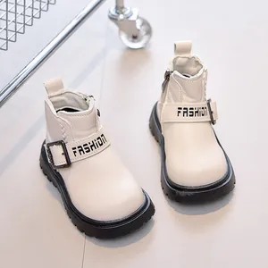 Detail of cream children's Martin boots featuring side zipper and fashion buckle strap